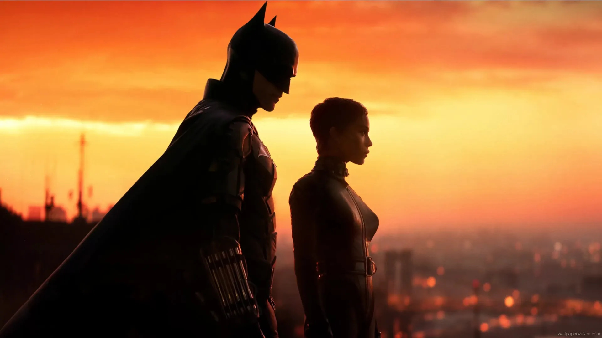 Batman and Catwoman standing together on a Gotham rooftop under the moonlight, with city lights shimmering in the background, cinematic live wallpaper