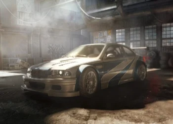 BMW M3 GTR from Need for Speed Most Wanted racing through city streets with headlights on and motion blur – wallpaper.