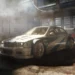 BMW M3 GTR from Need for Speed Most Wanted racing through city streets with headlights on and motion blur – wallpaper.