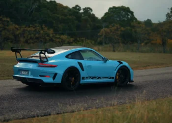 Blue Porsche 911 GT3 RS sports car with carbon spoiler and aggressive stance under city lights in a high-performance live wallpaper
