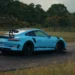 Blue Porsche 911 GT3 RS sports car with carbon spoiler and aggressive stance under city lights in a high-performance live wallpaper