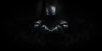 Dark shadowy Batman figure emerging from darkness with glowing bat symbol on chest live wallpaper