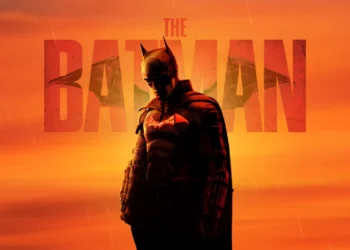 Batman standing under an orange sky with rain and glowing bat emblem in cinematic The Batman live wallpaper