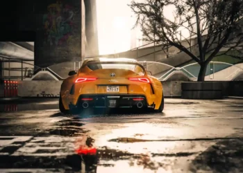 Yellow Toyota Supra parked in cinematic city setting with glowing tail lights reflecting on rain-soaked street in a live wallpaper
