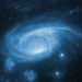 A glowing blue spiral galaxy surrounded by stars, nebula clouds, and deep space darkness in a serene cosmic scene live wallpaper.