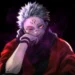 Sukuna Menacing Smile Live Wallpaper 10 Sukuna sitting with a menacing smile, glowing red eyes, dark cursed smoke around him, red cloak, and a black void background in an intense anime villain live wallpaper