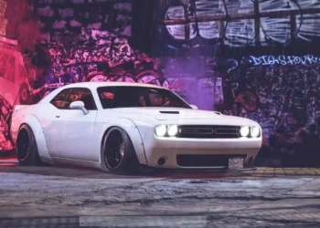 White Dodge Challenger parked under neon graffiti walls in the rain with reflections on wet pavement live wallpaper