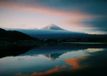 Mount Fuji Pastel Sky Live Wallpaper 1 Mount Fuji at sunrise with pastel sky, soft pink and orange clouds, calm reflective lake mirroring the mountain live wallpaper