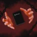 Death Note black notebook floating between hands in red dark background with chains symbolic power and control anime aesthetic wallpaper
