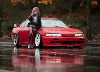 Pink-haired anime girl leaning on a red Nissan Silvia in a rainy autumn parking lot with reflective wet pavement and cinematic JDM street racing atmosphere wallpaper