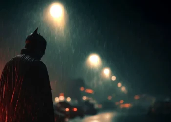 Batman standing in heavy rain beneath glowing streetlights on a dark Gotham street in Batman Dark Knight Rain Live Wallpaper.