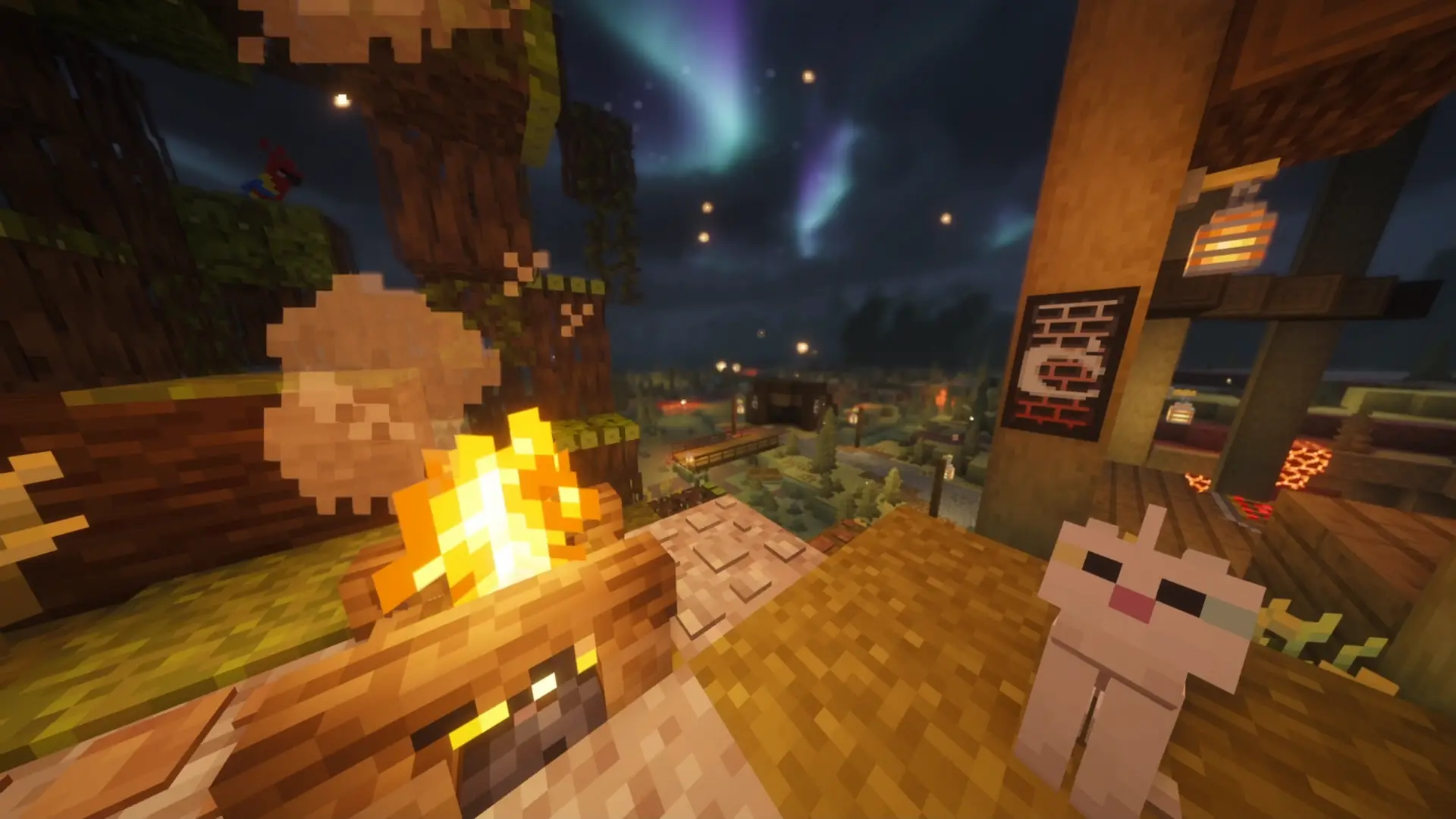 Cozy Minecraft campfire with a white cat, glowing lanterns, and colorful northern lights over a peaceful nighttime village in Cozy Minecraft Campfire Night Live Wallpaper.