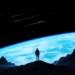 Lone Explorer on Alien Planet Live Wallpaper 10 Lone explorer standing on an alien planet overlooking a massive glowing blue world and star-filled space wallpaper.