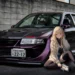 Mitsubishi Evo Anime Girl JDM Live Wallpaper 10 Modified Mitsubishi Evo JDM sports car with a blonde anime girl sitting beside it in an urban setting live wallpaper.