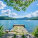 Peaceful Blue Lake Mountain Nature Live Wallpaper 10 Peaceful blue lake surrounded by green forests and mountains under a bright summer sky live wallpaper.