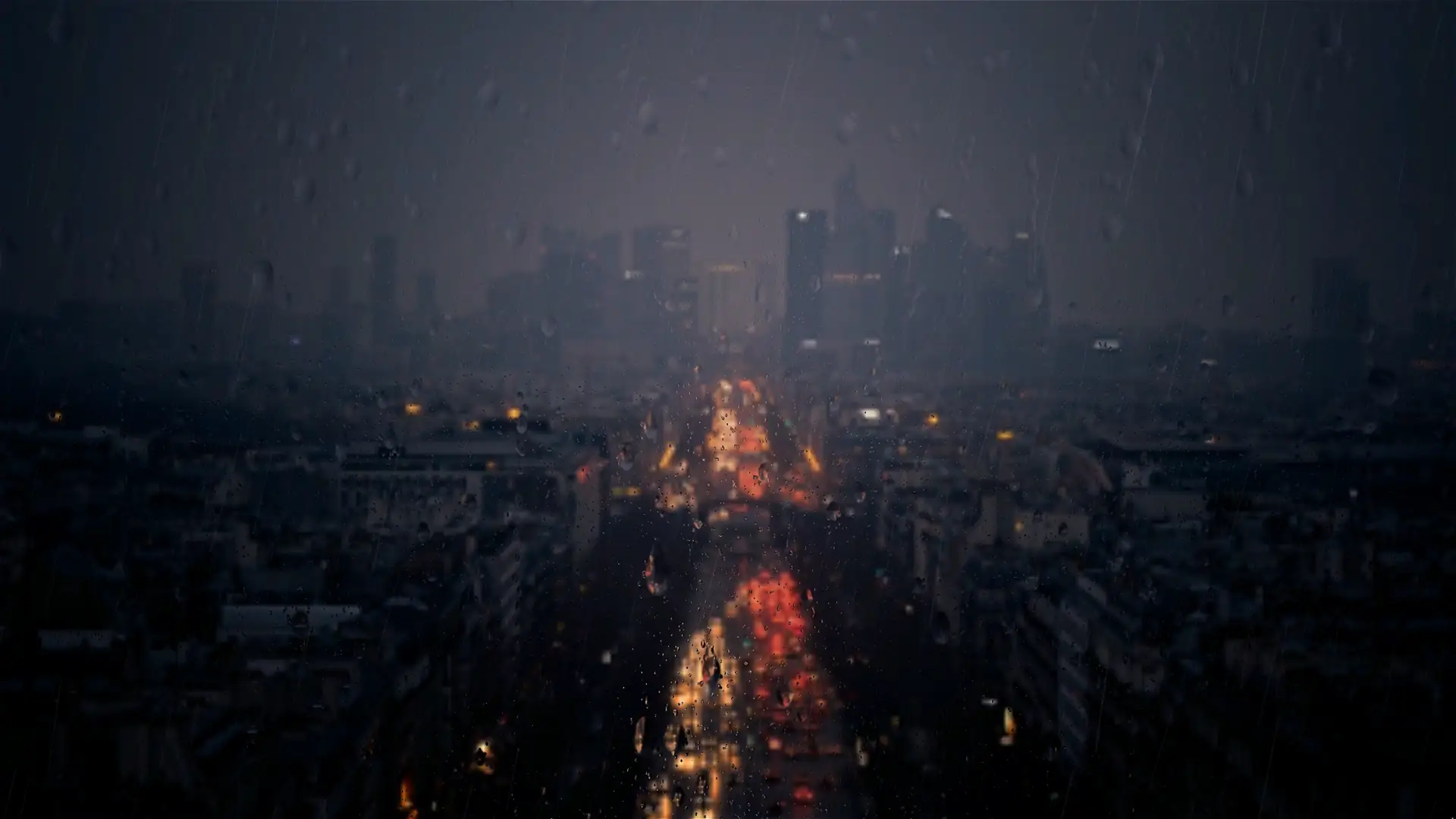 Rainy city viewed through a window covered in raindrops with blurred glowing lights live wallpaper