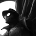 Spider-Man Noir wearing a fedora and trench coat beneath a glowing full moon in dark black and white live wallpaper.