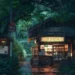 Cozy Japanese Store in Rain Live Wallpaper 10 Cozy Japanese convenience store glowing with warm lights during rainfall, surrounded by lush green forest trees, bicycles, Japanese street signs, and wet stone pavement in a 4K live wallpaper.