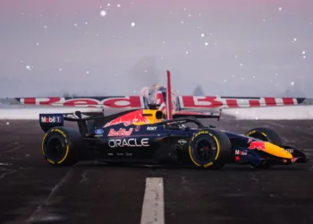 Red Bull F1 car parked in front of a Red Bull stunt plane on a snowy wet runway live wallpaper