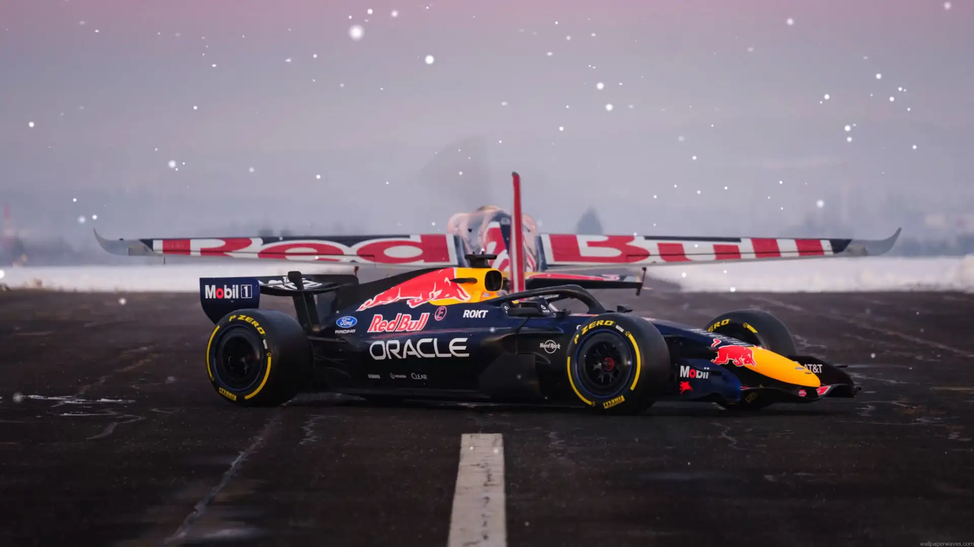 Red Bull F1 car parked in front of a Red Bull stunt plane on a snowy wet runway live wallpaper