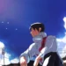Yuta Okkotsu Blue Sky JJK Live Wallpaper 10 Yuta Okkotsu from Jujutsu Kaisen sitting in his white sorcerer uniform beneath a vibrant blue sky with fluffy clouds, flying birds, and Japanese rooftops live wallpaper